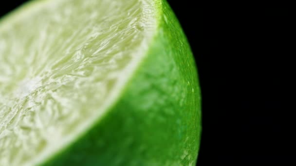 Macro shot of fresh green lime rotating on dark surface. 4K close up footage. - Footage, Video