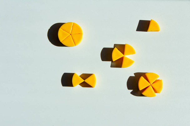 игрушечные сыры, разрезанные на куски. концепция математических дробей и частей одного целого
. - Фото, изображение
