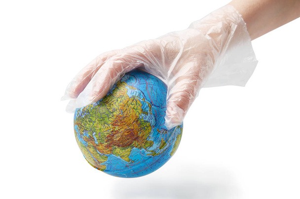 The humanhand in plastic glove holds the planet earth.  Isolated white background. - Foto, Bild