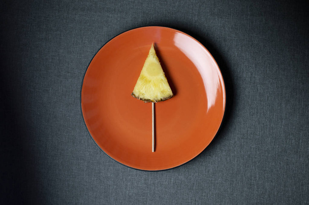 パイナップルの小片がアイスクリームの形で大きな皿の上にある - 写真・画像