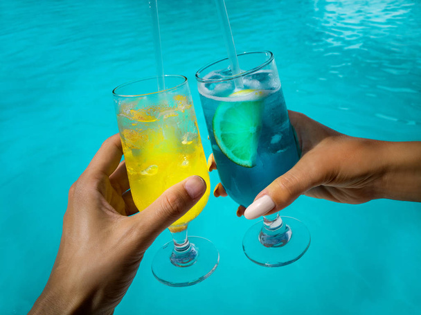 gesundes Getränk an einem karibischen Strand. Ananas und Kokosnuss am Strand zwischen Palmen und Pool. - Foto, Bild