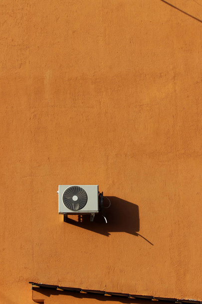 one outer industrial air conditioners are cooling the air in a large shopping center in the summer. orange brick wall background. - Photo, Image
