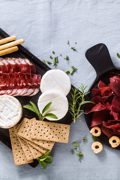 cold cuts and cheese are served on a tray on a table with white  - Foto, Imagem