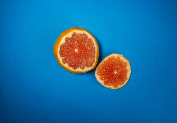 Sliced grapefruit on a blue background - Foto, Imagen
