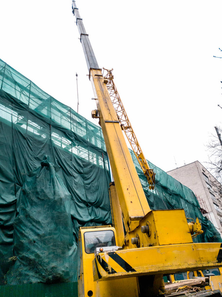 Изображение большого мобильного крана, работающего на строительной площадке
 - Фото, изображение