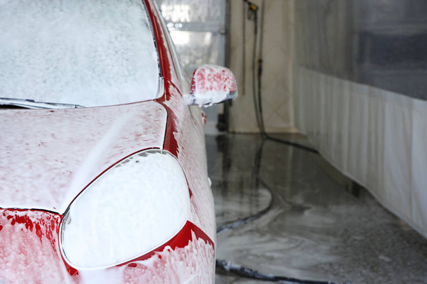 Auto covered with foam at car wash, space for text. Cleaning service - Φωτογραφία, εικόνα