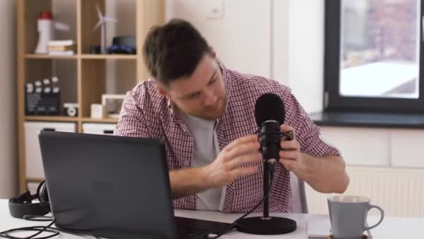 man in headphones with laptop speaks to microphone - Metraje, vídeo