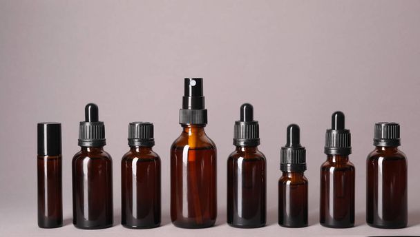 Cosmetic bottles of essential oils on color background - Valokuva, kuva