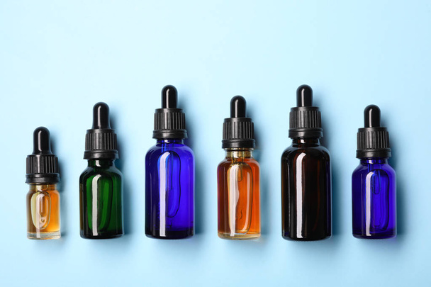 Flat lay composition with cosmetic bottles of essential oils on color background - Фото, зображення