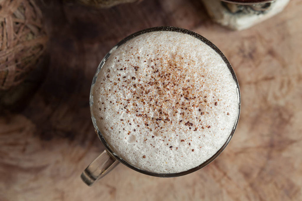 a glass cup of coffee, cappuccino with a frothiness, sprinkled with grated chocolate and cinnamon - Fotoğraf, Görsel