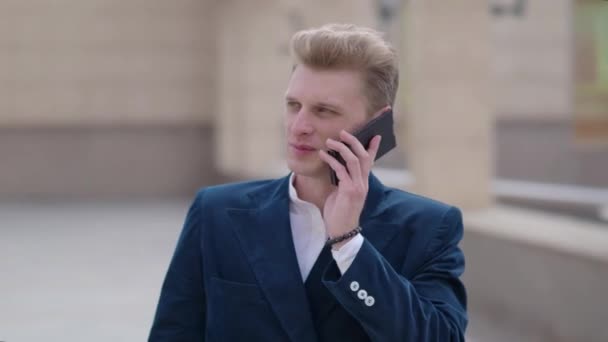 Muž chytrý telefon, volá na mobil v noci ve městě. Pohledný mladý obchodní muž mluví o smartphone, usmíval se šťastný nosit oblek bunda venku. Městské mužské professional v jeho 20s - Záběry, video