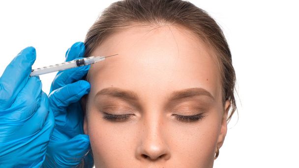Face needle injection. Young woman cosmetology procedure. Doctors hands in gloves. - Photo, Image