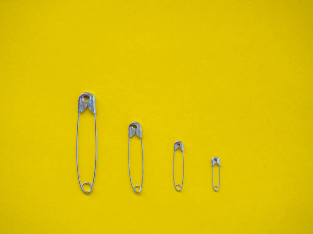 Several safety pins of different sizes. Concept of diversity and inclusion - Фото, зображення