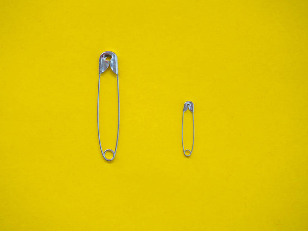 Several safety pins of different sizes. Concept of diversity and inclusion - Foto, imagen