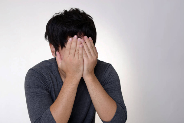 Ο άνθρωπος που κλαίει απομονώνεται σε γκρι φόντο - Φωτογραφία, εικόνα