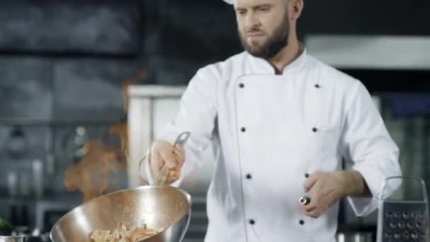 Chef koken voedsel met brandende vuur in slow motion. Gerichte chef-kok gooien voedsel - Video