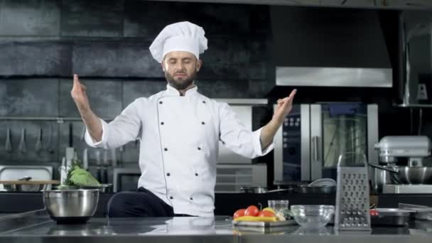 Chef man poseren in professionele keuken. Chef-kok maken van plezier in meditatie pose. - Video