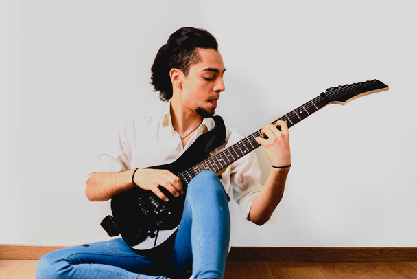 Millenial mladík sedící na podlaze doma hraje elec - Fotografie, Obrázek