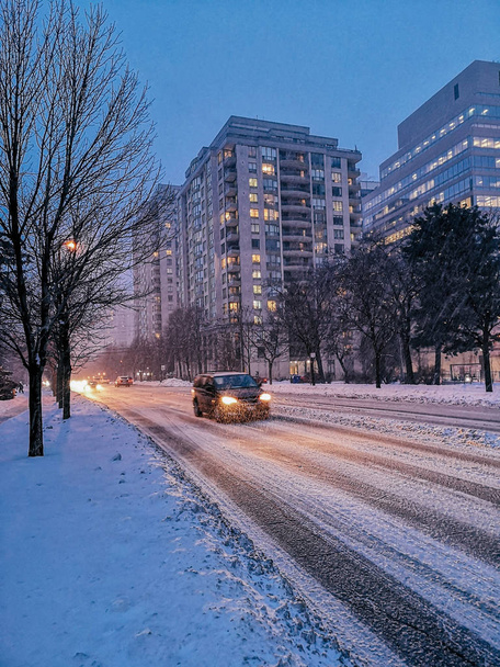 Paisaje panorámico de la ciudad de invierno al aire libre Toronto por la noche. Edificios, casas, árboles, caminos y calles cubiertas de nieve. Fuertes tormentas de nieve cataclismo de desastres naturales
.  - Foto, Imagen