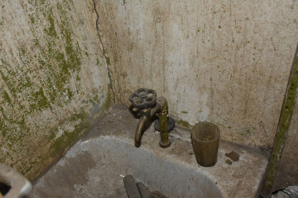 Vanha hylätty kylpyhuone ruosteisella vesihanalla - Valokuva, kuva