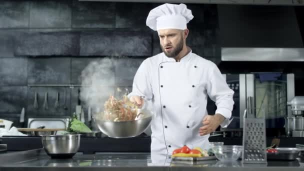 Koch kocht Essen in Küche Restaurant. Konzentrierter Koch wirft mit Lebensmitteln. - Filmmaterial, Video