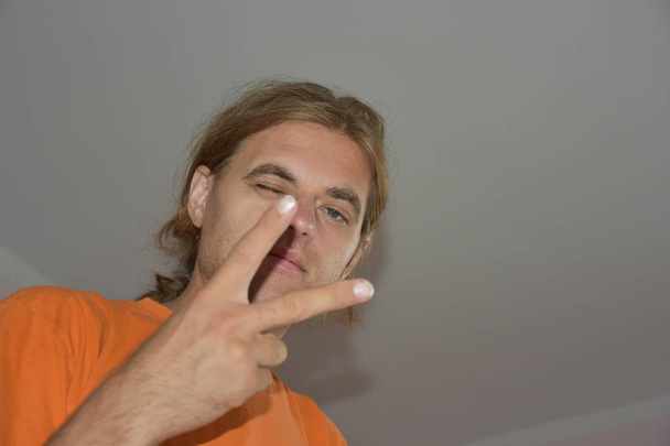 Portrait of man with long hair gesturing showing peace - Φωτογραφία, εικόνα