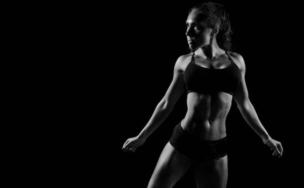 Fit athletic sporty woman posing on black background - Fotoğraf, Görsel