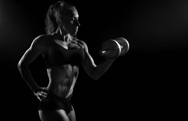 Muscular fitness cross fit bodybuilder posing with dumbbell - Фото, зображення