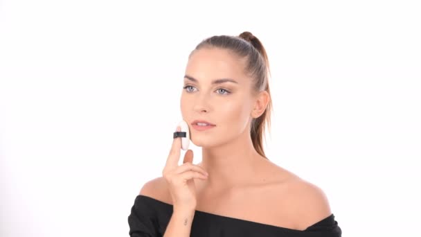 Beauty concept. Young woman applying blusher on her face with powder puff. - Video, Çekim