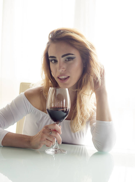 Jovem mulher bonita com copo de vinho tinto olhando para a câmera
  - Foto, Imagem