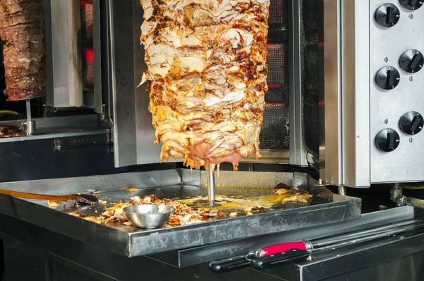 Szef kuchni, który kroczy tradycyjne tureckie jedzenie Doner Kebab w ulicznym sklepie spożywczym. Sprzedawcy uliczni w Stambule. - Zdjęcie, obraz