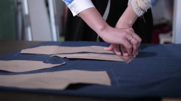 Kobiece ręce wzór śledzenia na tkaninie w warsztacie - Materiał filmowy, wideo