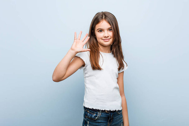 Cute girl smiling cheerful showing number five with fingers. - Photo, Image