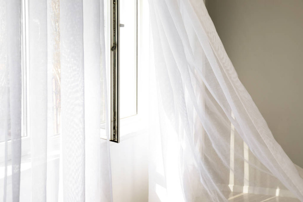Ventana abierta con cortinas de luz en la habitación
 - Foto, Imagen