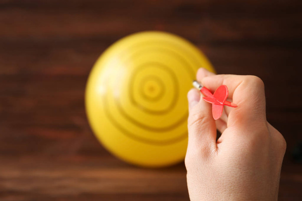 Darts player using balloon as dartboard, closeup - Photo, Image