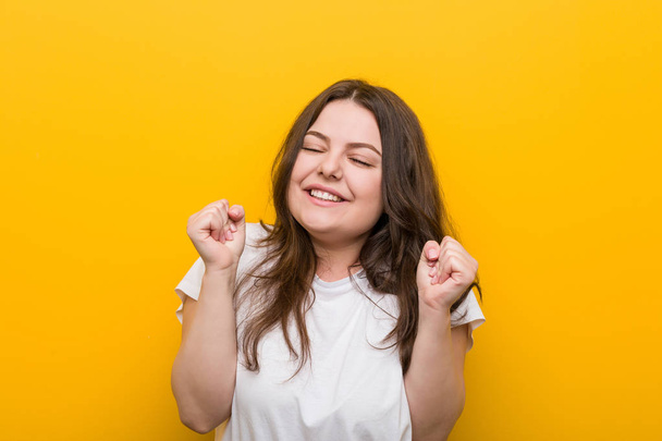 Young curvy plus size woman raising fist, feeling happy and successful. Victory concept. - Valokuva, kuva