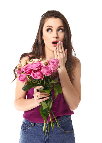 Surprised young woman with bouquet of flowers on white background - Foto, imagen