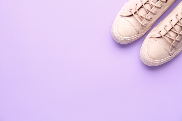 Pair of stylish casual shoes on color background - Foto, afbeelding