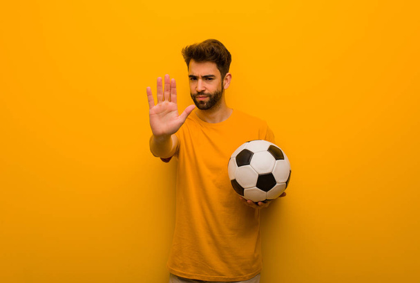 Jonge voetballer man hand in hand in de voorkant - Foto, afbeelding