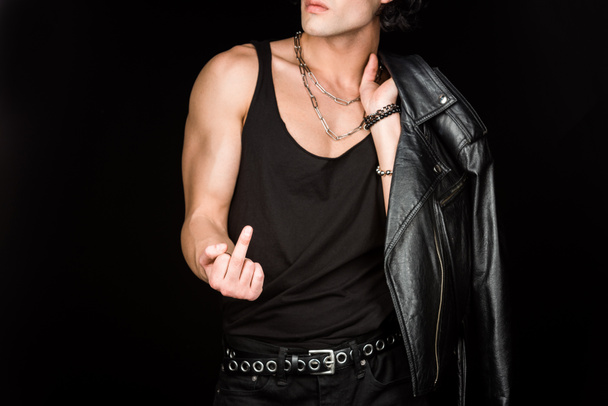 cropped view of man showing middle finger and holding leather jacket isolated on black  - Foto, Bild