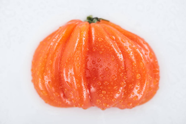 άνω όψη της ολικής κόκκινης ντομάτας με σταγόνες νερού που απομονώνονται σε λευκό - Φωτογραφία, εικόνα