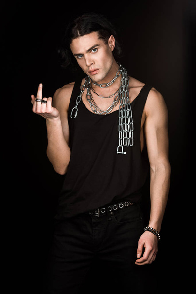 handsome man with chains around neck showing middle finger isolated on black  - Φωτογραφία, εικόνα