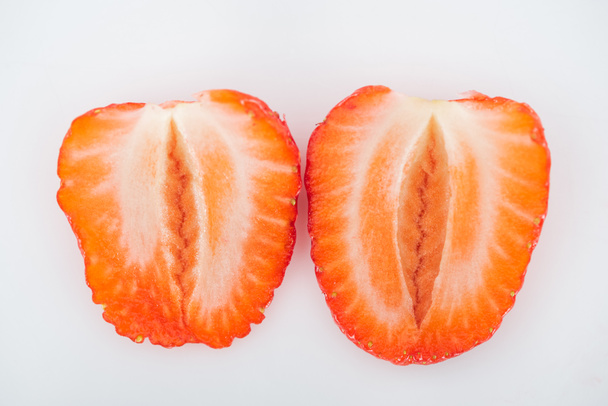 close up view of fresh ripe red strawberry halves on white background - 写真・画像
