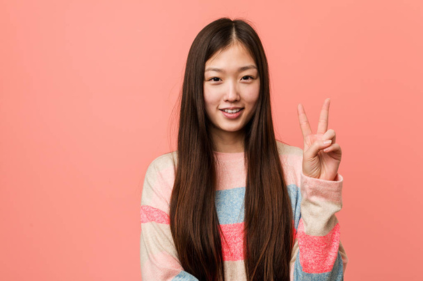 Young cool chinese woman showing number two with fingers. - Photo, Image