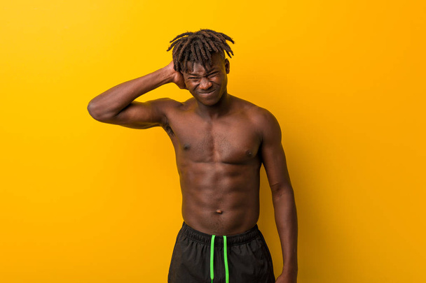 Young black man shirtless wearing swimsuit suffering neck pain due to sedentary lifestyle. - Fotoğraf, Görsel