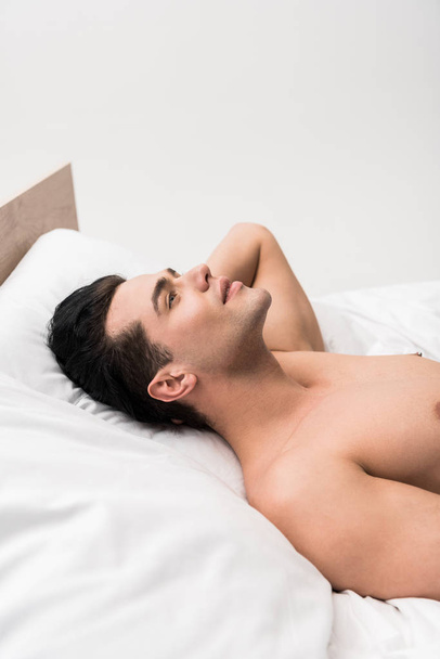 shirtless and cheerful man lying on bed at home  - Photo, Image