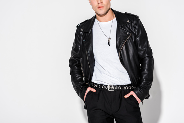cropped view of man in leather jacket standing with hands in pockets on white  - Photo, Image
