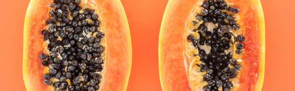 panoramic shot of papaya halves with black seeds isolated on orange - Photo, Image