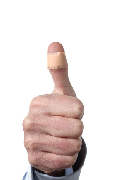 male man showing thumb with a plaster isolated on white background with clipping path and copy space for your text - Photo, Image