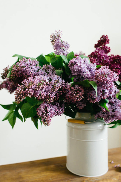 Buquê roxo de flores lilás em um vaso elegante na mesa de madeira
 - Foto, Imagem